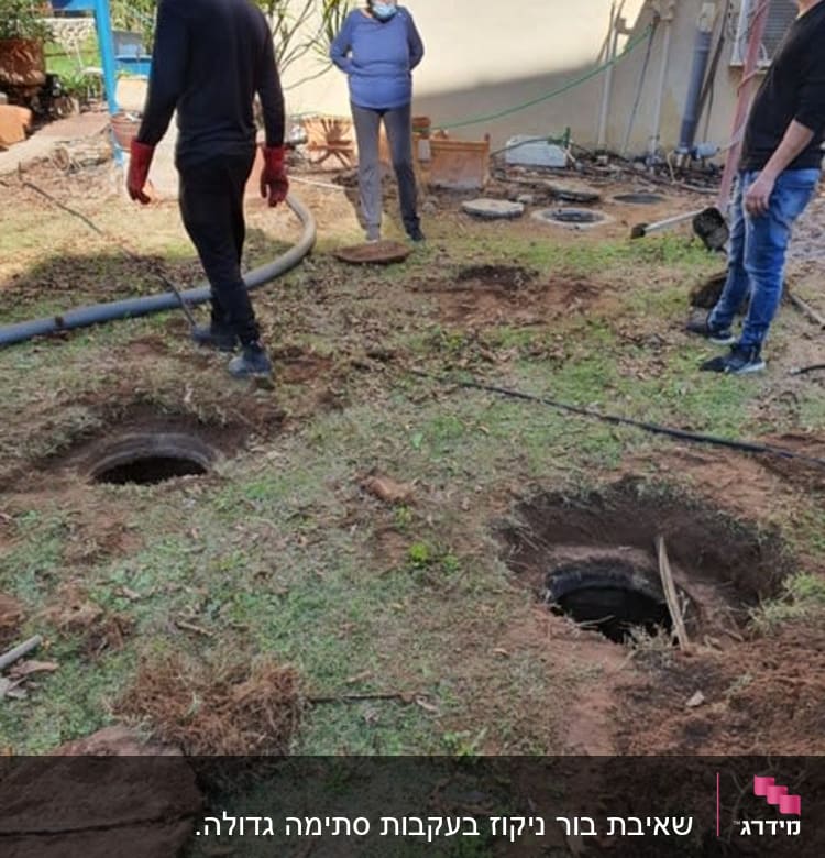 שלושה אנשים ליד בורות פתוחים עם צינור גדול